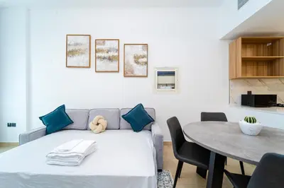 a living room with a couch and a table at New Contemporary Lux and Pool & Kids Amenities in JVC in Dubai