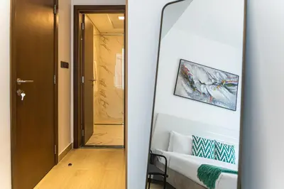 a mirror in front of a room with a bed at New Contemporary Lux and Pool & Kids Amenities in JVC in Dubai
