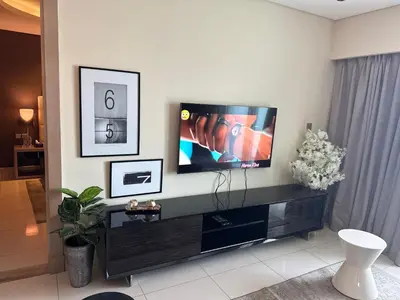 a living room with a flat screen tv on a wall at Royal Montania by DAMAC Paramount , Burj Khalifa View in Dubai