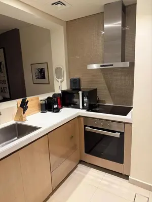 a kitchen with a sink and a stove top oven at Royal Montania by DAMAC Paramount , Burj Khalifa View in Dubai
