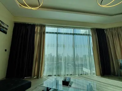 a living room with a glass table and a large window at Dubai Skyline & Creek View - Homeyvillas in Dubai