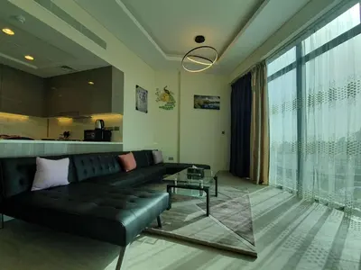a living room with a black couch and a large window at Dubai Skyline & Creek View - Homeyvillas in Dubai