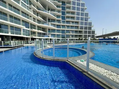 a large swimming pool in front of a building at Dubai Studio Retreat Pool, Gym, Balcony & Queen Bed for Two in Dubai