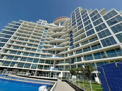a large building with a swimming pool in front of it at Dubai Studio Retreat Pool, Gym, Balcony & Queen Bed for Two in Dubai