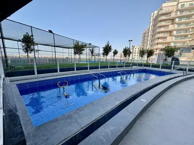 a large swimming pool with blue water in a building at Dubai Studio Retreat Pool, Gym, Balcony & Queen Bed for Two in Dubai