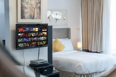 a bedroom with a bed and a tv on the wall at Luxury Living in Matrix Tower Near Sports City in Dubai