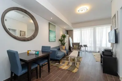 a living room with a table and a dining room at Luxury Living in Matrix Tower Near Sports City in Dubai