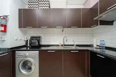 a kitchen with a sink and a washing machine at Luxury Living in Matrix Tower Near Sports City in Dubai