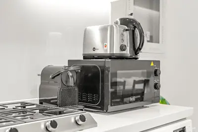a microwave sitting on top of a stove in a kitchen at Business Bay Studio Near Dubai Mall, Burj Khalifa & Downtown Hotspots in Dubai