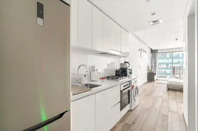 a white kitchen with a sink and a stove at Business Bay Studio Near Dubai Mall, Burj Khalifa & Downtown Hotspots in Dubai