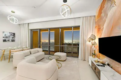 a living room with white furniture and a flat screen tv at FIRST CLASS 2BR Sun, Views & Serenity in Dubai