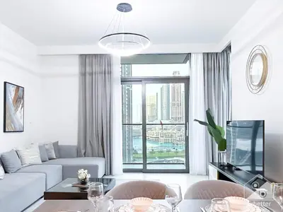 a living room with a white couch and a large window at Luxurious 2BR in Burj Crown with Burj Khalifa View in Dubai