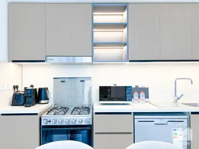 a kitchen with white cabinets and a stove top oven at Luxurious 2BR in Burj Crown with Burj Khalifa View in Dubai