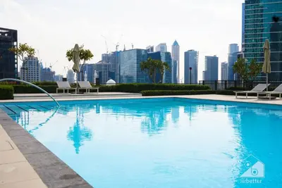 a large blue swimming pool with a city skyline at Luxurious 2BR in Burj Crown with Burj Khalifa View in Dubai