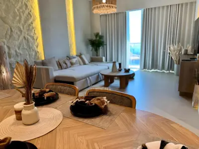 a living room with a table and a couch at Top floor Grande 2BR Luxe Panoramic Sea View BohemianStyle in Dubai