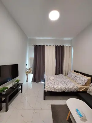 a living room with a bed and a flat screen tv at Urban Studio - Walk to Metro - Homeyvillas in Dubai