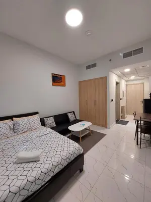 a bedroom with a bed and a couch and a table at Urban Studio - Walk to Metro - Homeyvillas in Dubai