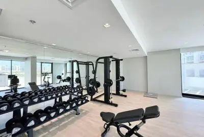 a gym with a lot of equipment in a room at COZY 1 BR Apartment in Dubai