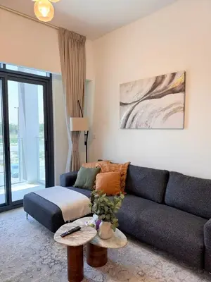 a living room with a couch and a table at COZY 1 BR Apartment in Dubai