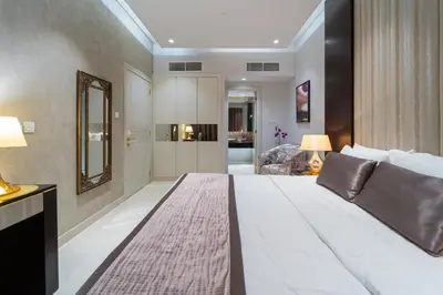 a large white bed in a room with a mirror at Near Dubai Mall Downtown Views Infinity Pool in Dubai