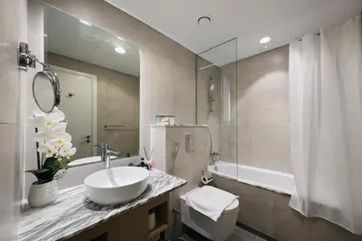 a bathroom with a sink and a toilet and a mirror at 2BR Burj Khalifa and Sea View Apartments in Paramount Hotel Midtown in Dubai