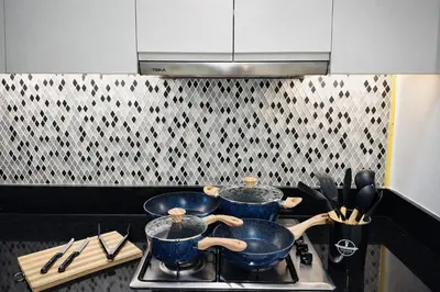 three pots on a stove in a kitchen at 2BR Burj Khalifa and Sea View Apartments in Paramount Hotel Midtown in Dubai