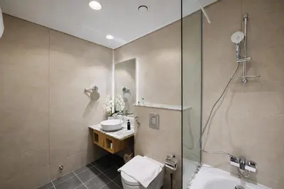 a bathroom with a shower and a toilet and a sink at 2BR Burj Khalifa and Sea View Apartments in Paramount Hotel Midtown in Dubai