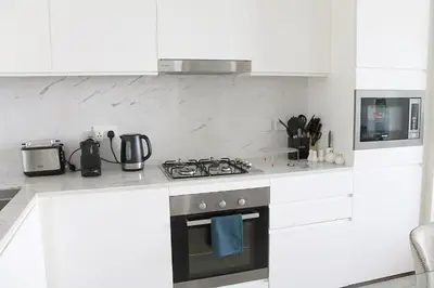 a kitchen with white cabinets and a stove top oven at Palace Residences luxurious 2 bedroom with breathtaking views in Dubai