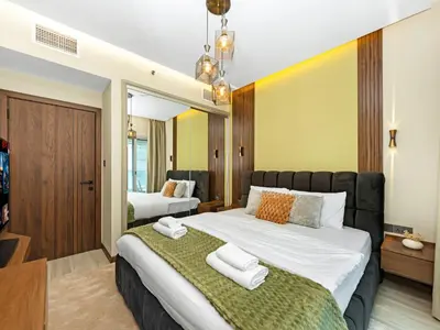 a bedroom with a large bed with towels on it at Stylish 1BHK Balcony with Canal View Near Shoba Metro Station in Dubai