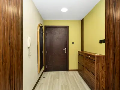 a hallway with a brown door and a wooden cabinet at Stylish 1BHK Balcony with Canal View Near Shoba Metro Station in Dubai