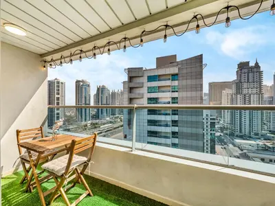 a balcony with a table and chairs and a view of the city at Stylish 1BHK Balcony with Canal View Near Shoba Metro Station in Dubai
