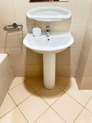 a bathroom with a white sink and a toilet at Tranquil & Elegant Studio in Dubai Sports City in Dubai