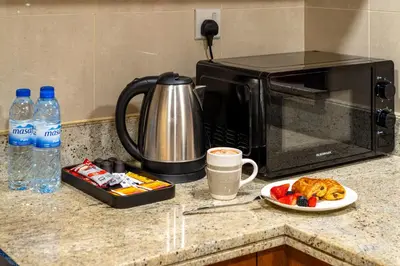 a kitchen counter with a microwave and a plate of food at Stylish 1BR Apartment near Burj Khalifa and Dubai Fountain, Downtown in Dubai