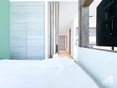a bedroom with a white bed with a tv on it at Balcony Bliss Cozy Studio with Marina Views in Dubai