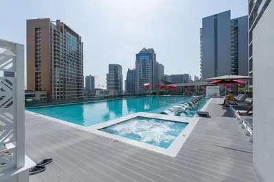 a swimming pool on the roof of a building at Vogue Downtown Mag 318 near Burj Khalifa and Dubai Mall, Studio Apartment with Balcony, Canal and City View, Access to all Amenities in Sabkhah