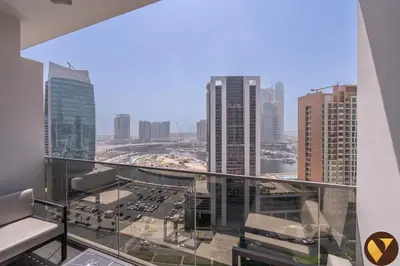 a view of a city from the balcony of a building at Vogue Downtown Mag 318 near Burj Khalifa and Dubai Mall, Studio Apartment with Balcony, Canal and City View, Access to all Amenities in Sabkhah