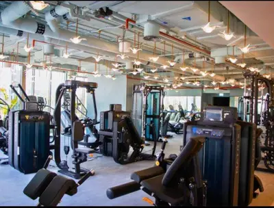 a gym with several treadmills and cardio machines at Vogue Downtown Mag 318 near Burj Khalifa and Dubai Mall, Studio Apartment with Balcony, Canal and City View, Access to all Amenities in Sabkhah