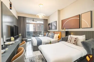a hotel room with two beds and a tv at Vogue Downtown Mag 318 near Burj Khalifa and Dubai Mall, Studio Apartment with Balcony, Canal and City View, Access to all Amenities in Sabkhah