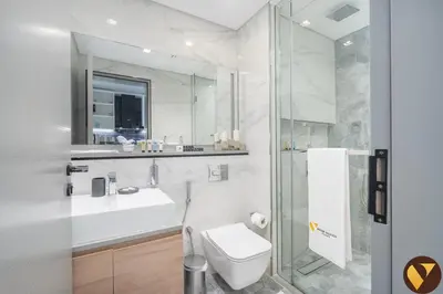a bathroom with a toilet and a sink and a shower at Vogue Downtown Mag318 near Burj Khalifa and Dubai Mall, Studio Apartment with Balcony, Canal and City View, Access to all Amenities in Sabkhah