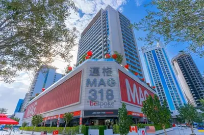 a building with a sign on it in a city at Vogue Downtown Mag318 near Burj Khalifa and Dubai Mall, Studio Apartment with Balcony, Canal and City View, Access to all Amenities in Sabkhah