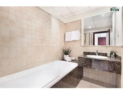 a bathroom with a tub and a sink and a mirror at Boho Studio Beachfront Ain Sea View JBR Walk 1min in Dubai