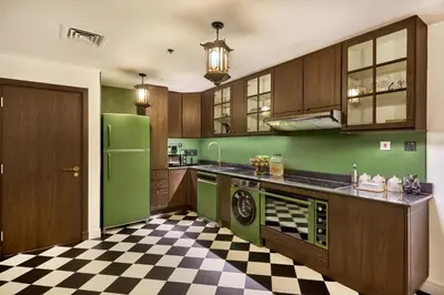 a kitchen with a green refrigerator and a checkered floor at Zen Den - Vintage Charm with full Sea View in Dubai