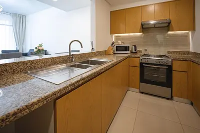 a kitchen with a sink and a stove at Luxury 2bdr apartment with Burj views & resort amenities in Dubai