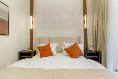 a bedroom with a white bed with two orange pillows at 313 Downtown Luxury Living at it's Finest in Dubai