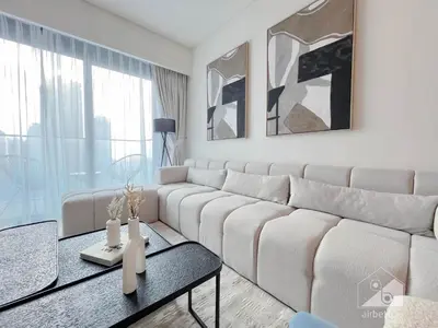 a living room with a white couch and a table at Burj Crown Luxury 2BR I Balcony & Panoramic Views in Dubai