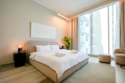 a bedroom with a bed and a large window at Stylish Studio at Concord Concept, JVC in Dubai