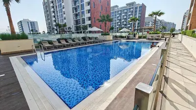 a large swimming pool with blue water in a city at Chic and comfortable Studio Near Downtown and Canal in Dubai