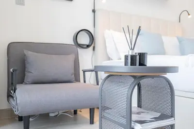 a side table and a chair in a bedroom at Chic and comfortable Studio Near Downtown and Canal in Dubai