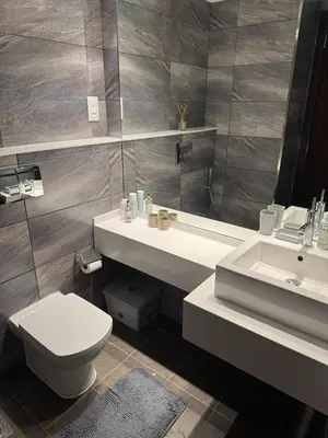 a bathroom with a sink and a toilet and a mirror at Elegant Master bedroom with view in Dubai