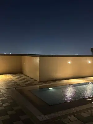 a building with a swimming pool at night at Elegant Master bedroom with view in Dubai